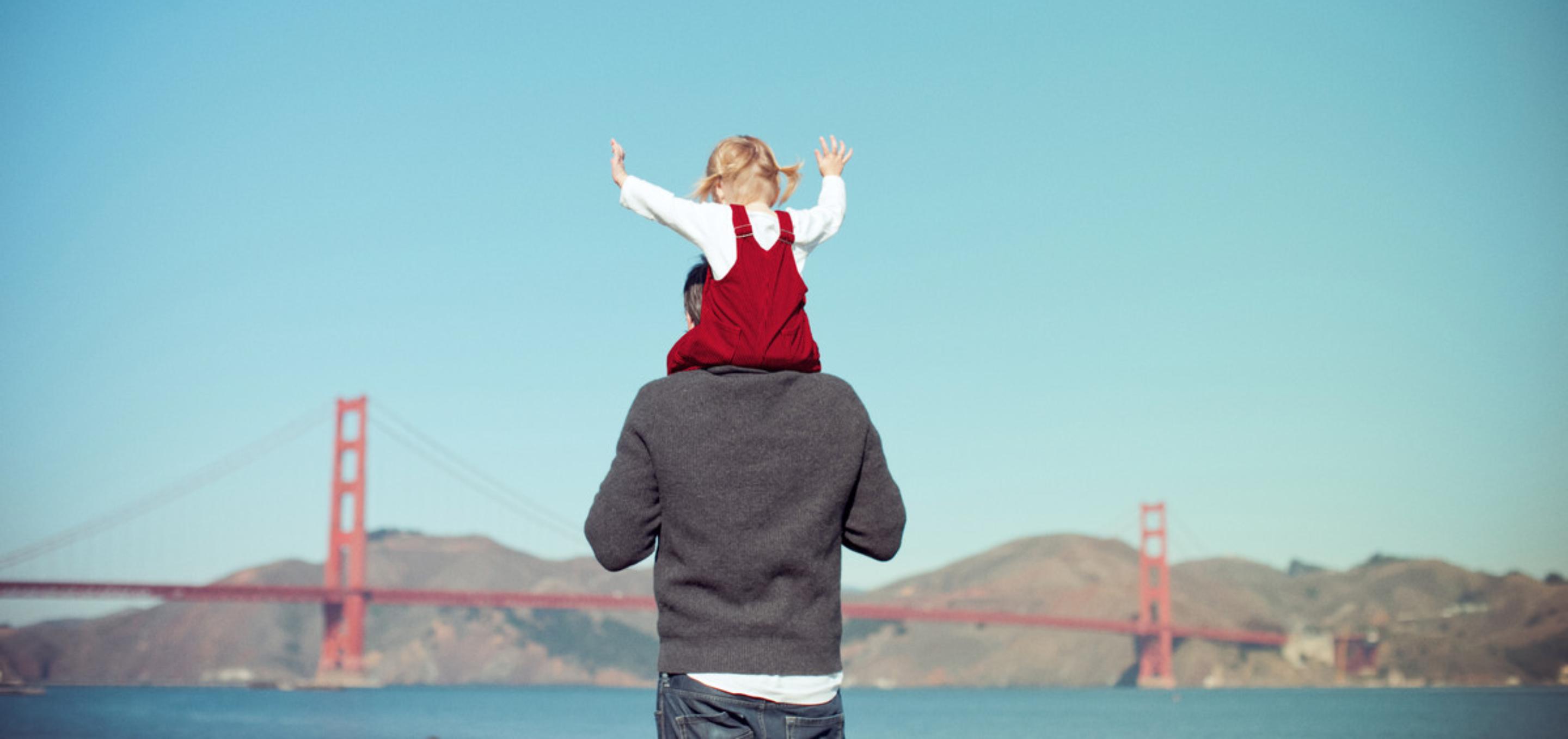 An image showing a child on a parents shoulders